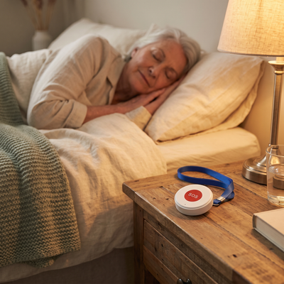 SOS pendant within arm's reach on the nightstand at night